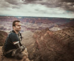 Kyle Maynard sitting on top of a mountain ridge